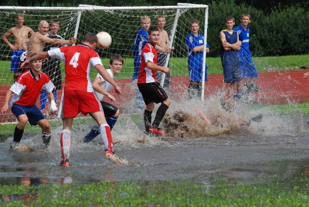 FOTO: Minifutbols ar dubļu un ūdenspolo piegaršu Aizputes stadionā