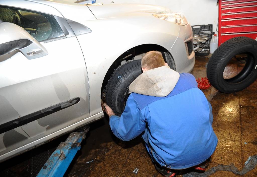 Vīrietim remonta laikā uzkrīt auto, kas ar trosēm piesiets pie koka zara