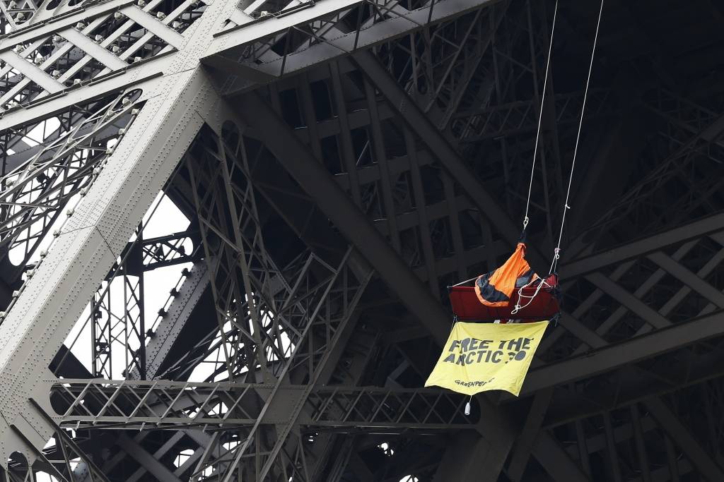 FOTO: Greenpeace aktīvists iekaras Eifeļa tornī, protestējot pret savu biedru turēšanu cietumā Krievijā