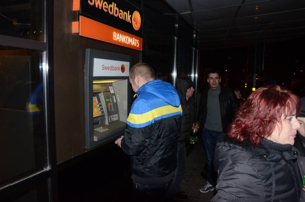 FOTO: Liepājā pie bankomāta priecājas par pirmajiem eiro